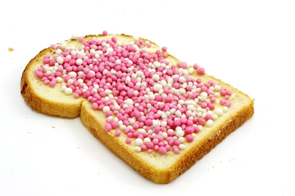 Rebanada de pan blanco con mantequilla y bolitas de colores, un verdadero manjar holandés, aislado en blanco — Foto de Stock