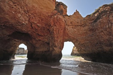 Rock in the ocean at Alvor in Portugal clipart