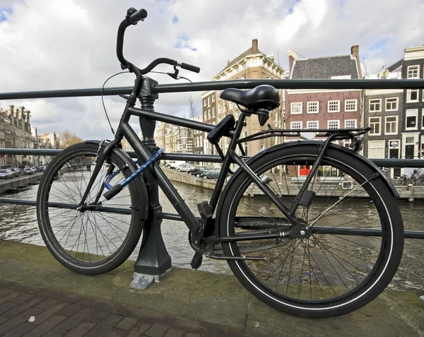 Vélo noir enchaîné au pont — Photo