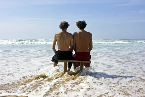 Two men gazing at a wild ocean in summertime — Stock Photo, Image