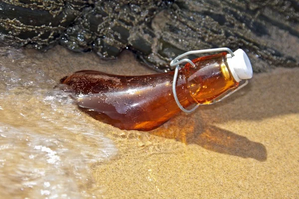 Garrafa lavada em terra na praia — Fotografia de Stock