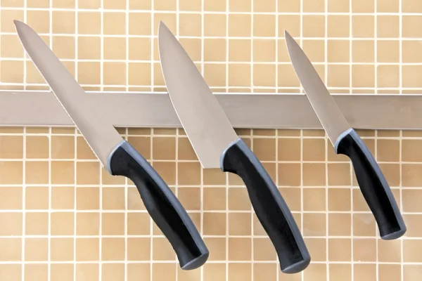 Three knives against the wall in the kitchen — Stock Photo, Image