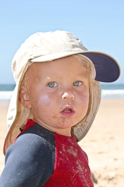 Söt liten pojke med krämig och sandiga ansikte på stranden — Stockfoto