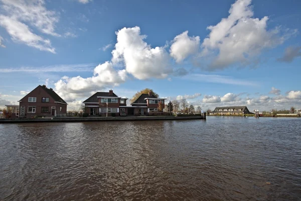 Typical dutch landscape: Houses along the waterline in the Netherlands — Stock Photo, Image