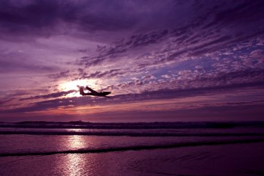 A romantic purple red sunset at the coast in the Netherlands clipart