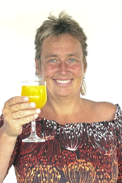 Beautiful mature woman with a glass of orange juice — Stock Photo, Image