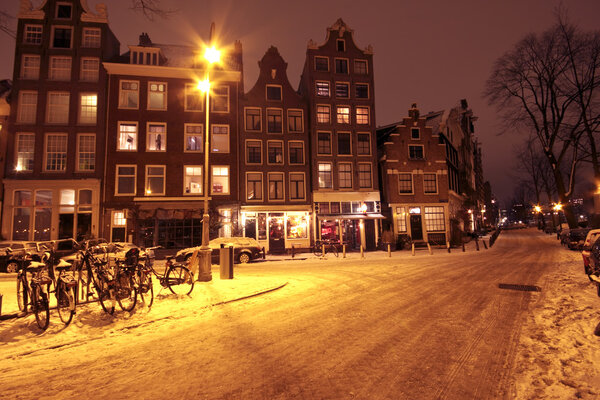 Cityscenic from Amsterdam covered with snow in the Netherlands at night