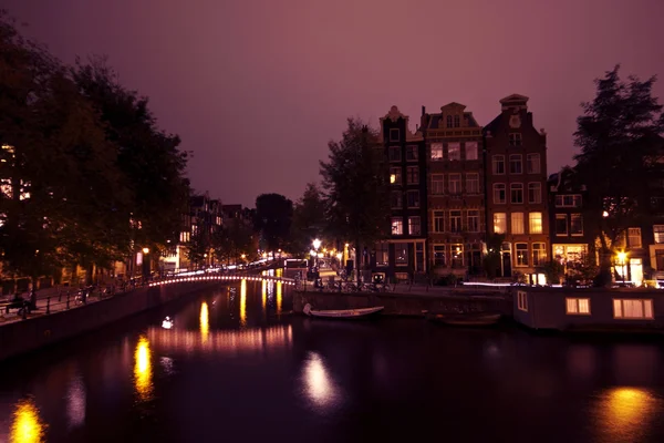 Амстердам ночью с рекой Амстел в Нидерландах — стоковое фото
