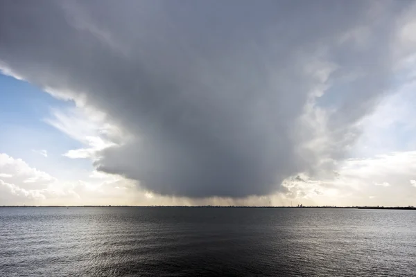 Mörka imponerande moln reflekterar i en lugn sjö — Stockfoto