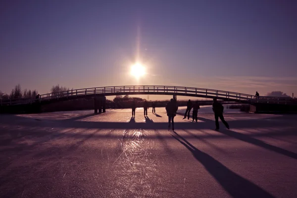Pattinaggio sul ghiaccio al tramonto sui canali nella campagna dei Paesi Bassi — Foto Stock