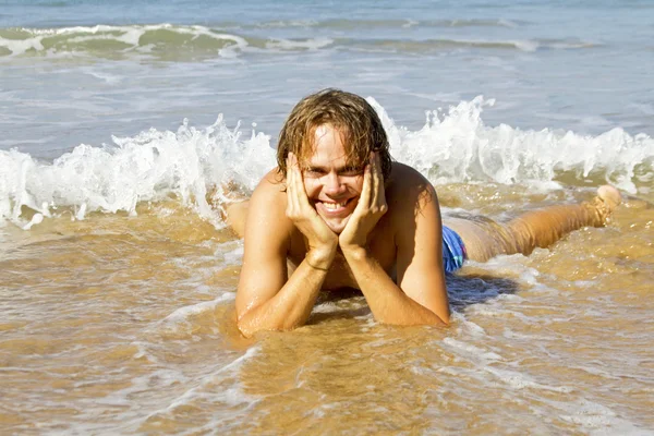 Young guy enjoying in the water from the ocean — Stock Photo, Image