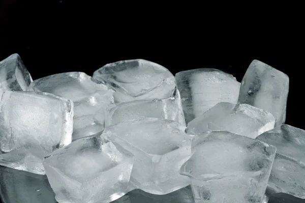 Cubos de gelo sobre um fundo preto — Fotografia de Stock