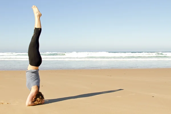 Kumsalda yoga egzersizleri yapıyor sağlıklı genç bir kadın — Stok fotoğraf