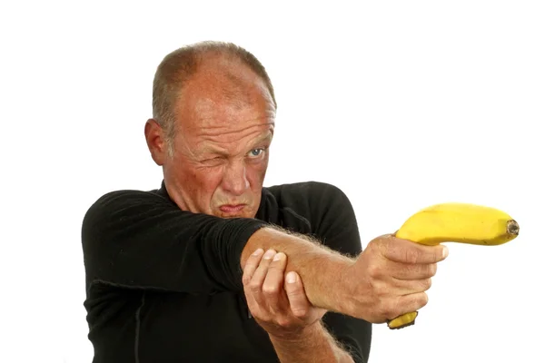 Человек, наставляющий свой банановый пистолет — стоковое фото