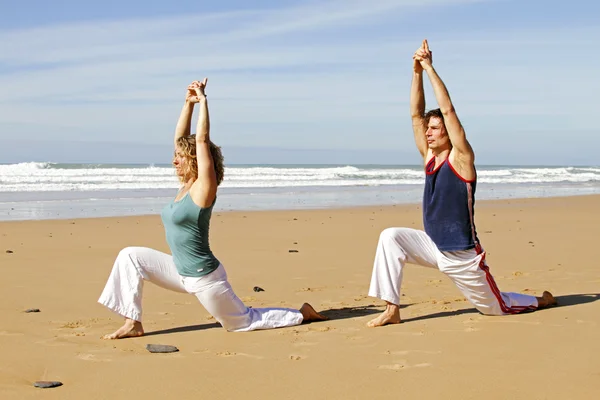 Fiatal pár, jóga gyakorlatok, a strandon — Stock Fotó