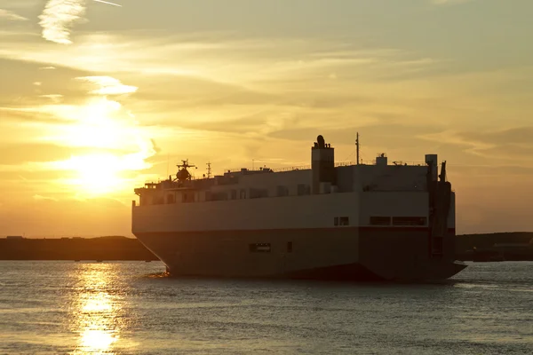 Vrachtschip cruisen bij zonsondergang in Nederland — Stockfoto