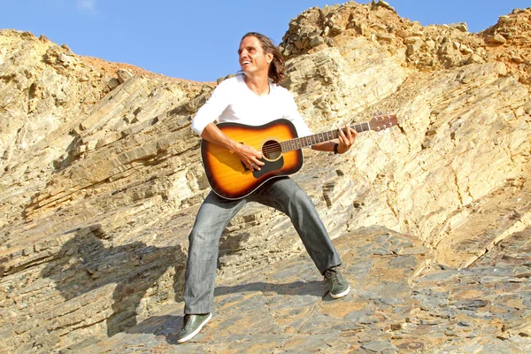 Гитарист на скалах — стоковое фото