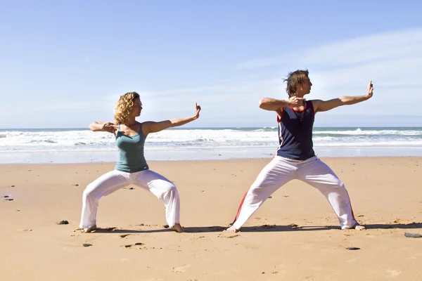 Junges Paar macht Yoga-Übungen am Strand — Stockfoto