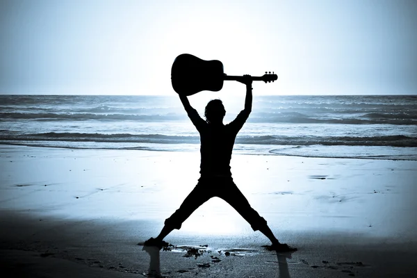 Гитарист на пляже ночью — стоковое фото