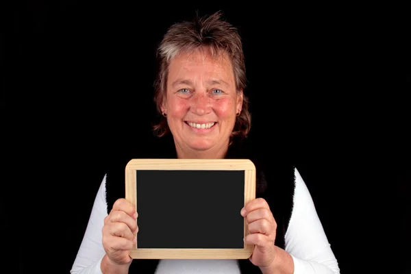 Beautiful mature woman holding an empty chalkboard — Stock Photo, Image