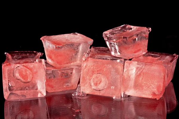 Cubos de gelo vermelho sobre um fundo preto — Fotografia de Stock