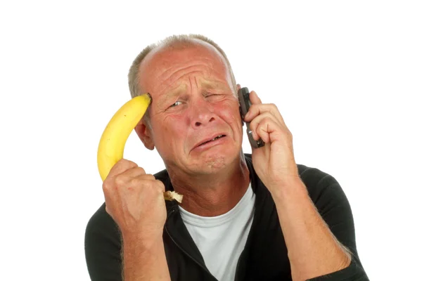 電話をかけながら彼を彼の頭のバナナ銃を指している絶望的な男 — ストック写真