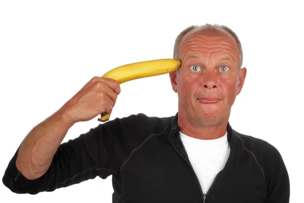 Відчайдушний чоловік вказує свою бананову зброю на голову — стокове фото