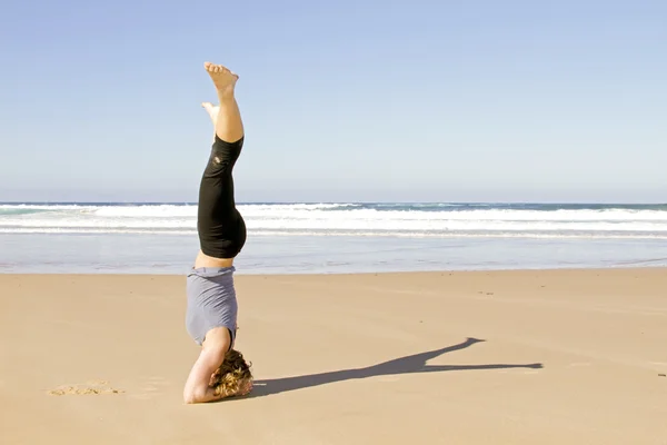 Young healthy woman doing yoga exercises at the beach — Stock Photo, Image