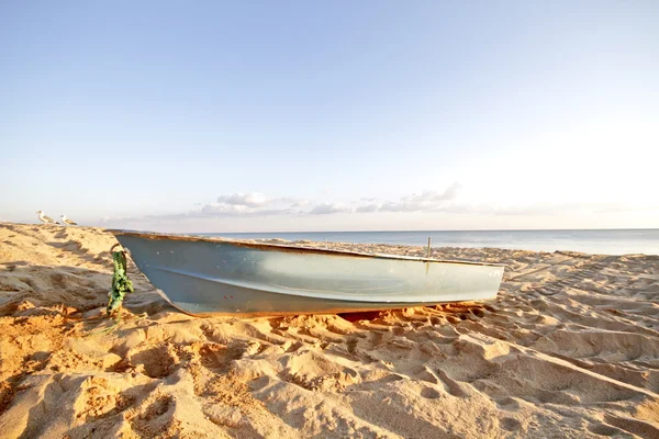 Лодка на пляже на закате — стоковое фото
