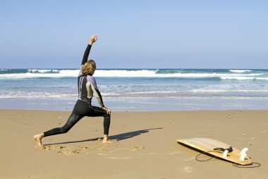 Young guy doing exercises before going to surf clipart