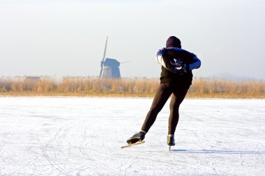 Genellikle Hollanda: buz donmuş bir göl manzaralı bir yel değirmeni üzerinde soğuk bir winterday