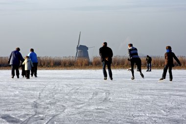 Genellikle Hollanda: buz donmuş bir göl manzaralı bir yel değirmeni üzerinde soğuk bir winterday