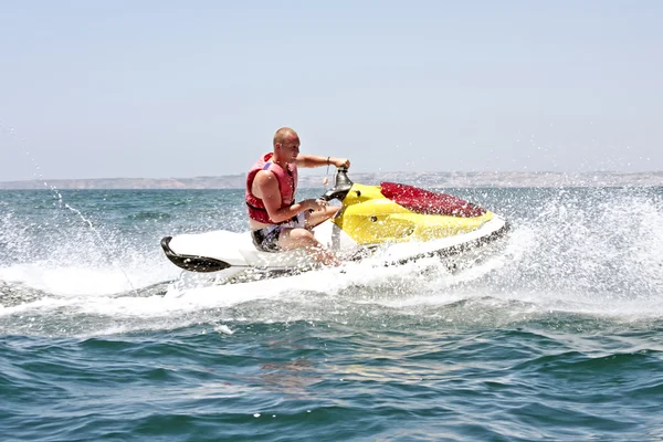 Young guy cruising on the atlantic ocean on a jet ski — Stock Photo, Image