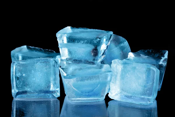 Cuburi de gheață albastre pe un fundal negru — Fotografie, imagine de stoc