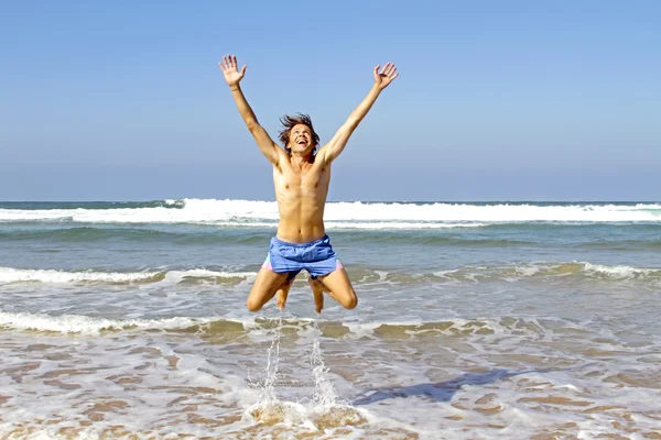 Um tipo feliz a saltar da água. — Fotografia de Stock