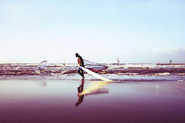 Surfista con su tabla de surf en la playa — Foto de Stock