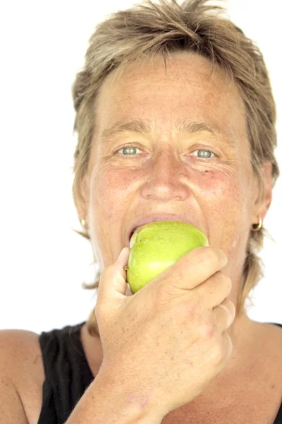 Υγιή μέσης ηλικίας γυναίκα που τρώει ένα μήλο — Φωτογραφία Αρχείου
