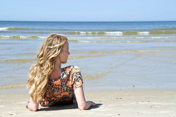 Vacker blond kvinna avkopplande vid vattnet — Stockfoto