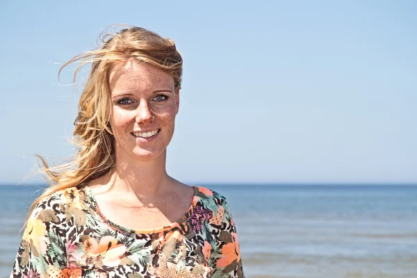 Mooie jonge blonde vrouw op het strand — Stockfoto