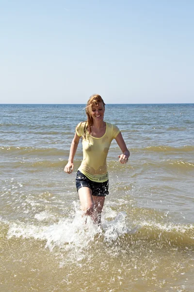 Young woman running out of the water — Stock Photo, Image