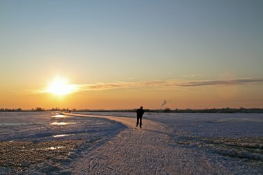 Ice skating in the countryside from the Netherlands at sunset clipart