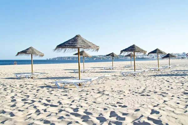 Sombrillas de paja y sillas de playa en la playa cerca del puerto de Lagos — Foto de Stock