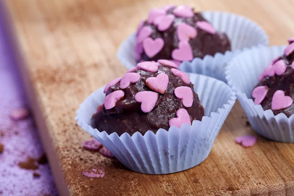 Pralinés de chocolate com corações cor de rosa — Fotografia de Stock
