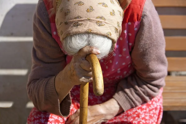 Hände einer alten Frau mit einem Stock — Stockfoto