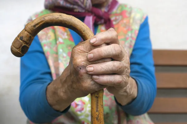 Hände einer alten Frau mit einem Stock Stockbild