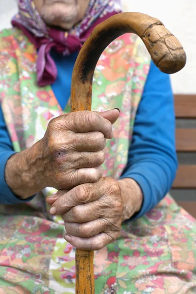 Hände einer alten Frau mit einem Stock Stockbild
