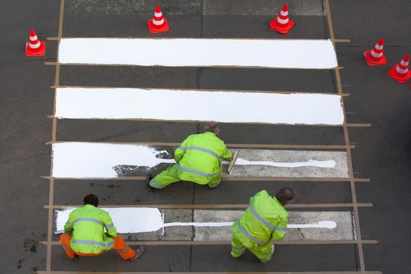 Workers painting crosswalk
