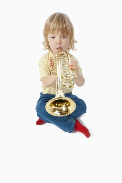 Мальчик с игрушечной трубой — стоковое фото