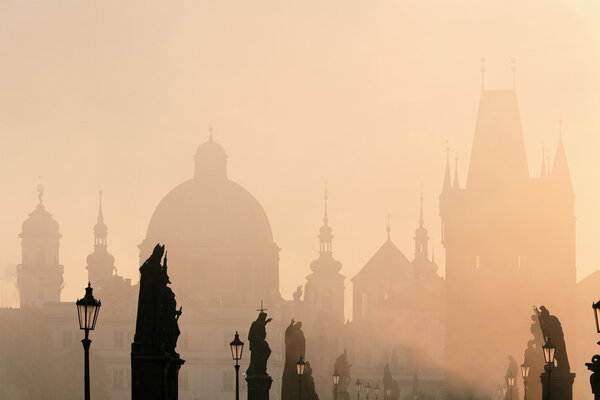 Prague - charles bridge and towers of the old town on foggy morning