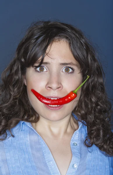 Mujer sosteniendo chile en su boca — Foto de Stock